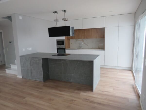 Cozinha por medida com design premium, ilha em cerâmica técnica e móveis em nogueira natural, projeto exclusivo de padrão elevado