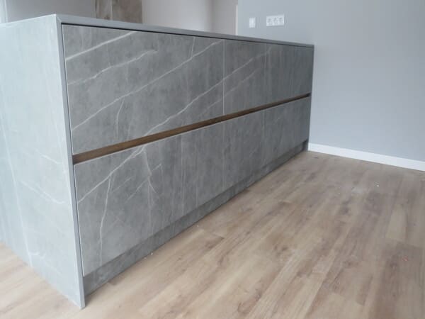 Detalhe de ilha de cozinha em cerâmica técnica, móveis por medida com elevada resistência e acabamento premium